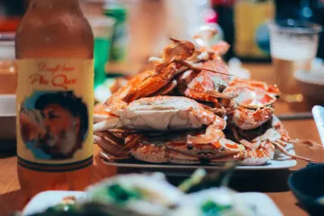 Cua và bia trên bàn gỗ